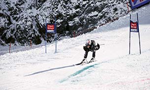 Ski racer skiing between race course gates.