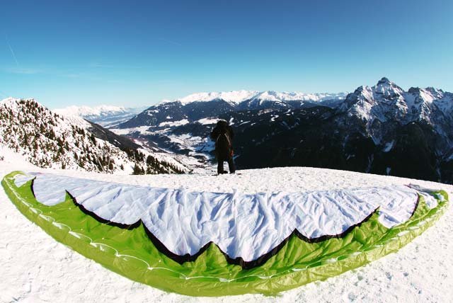 Paraglider spread over a snowy mountain