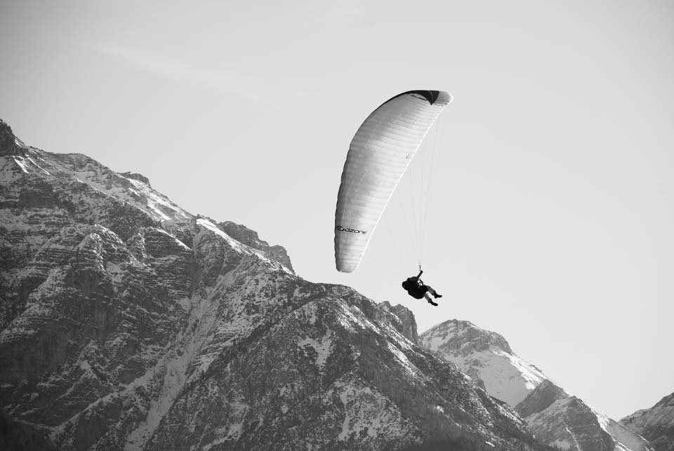 Paraglider flying in front of mountain peaks