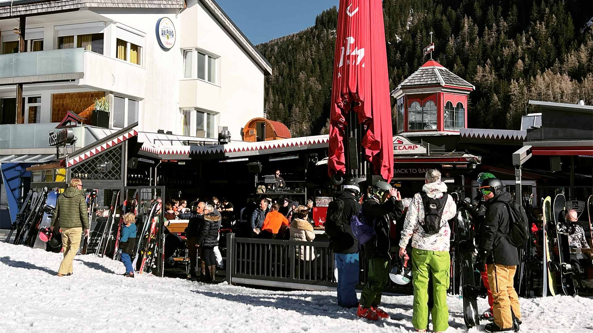 People standing on snow in front of a bar